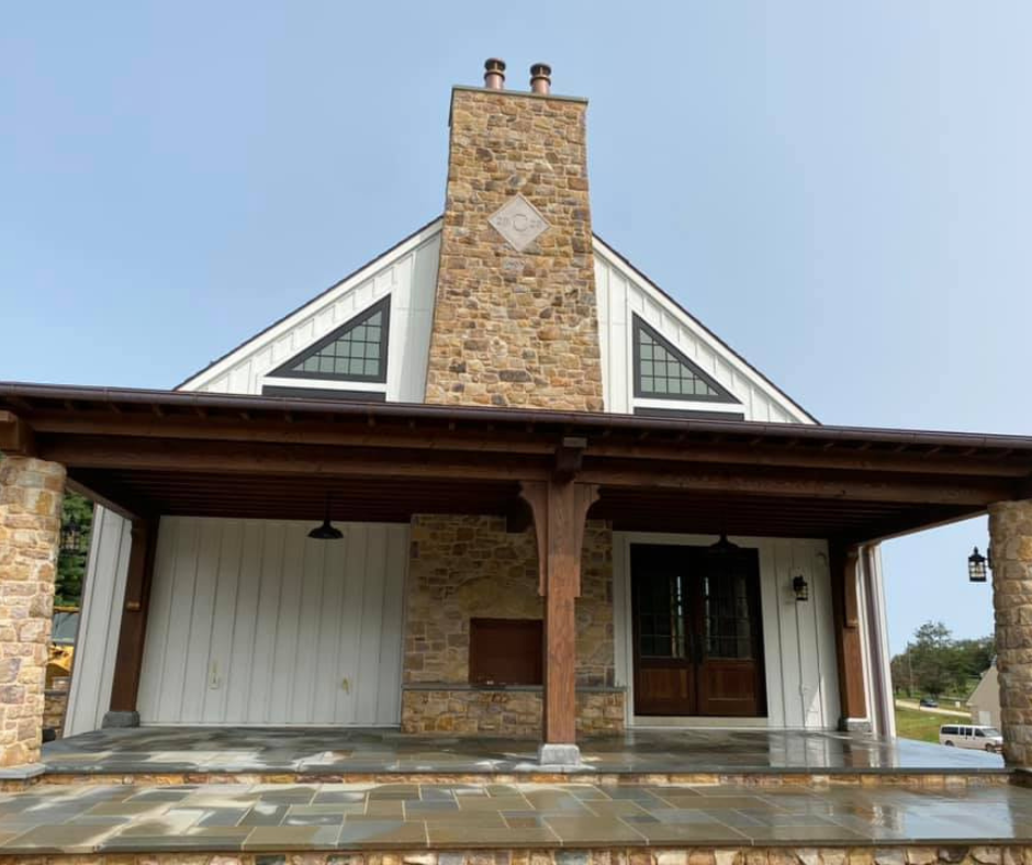 porch with outdoor stone fireplace and chimney