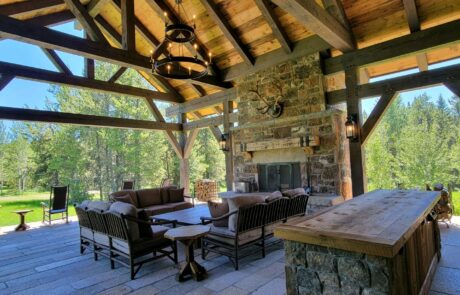 covered porch with seating area and stone fireplace