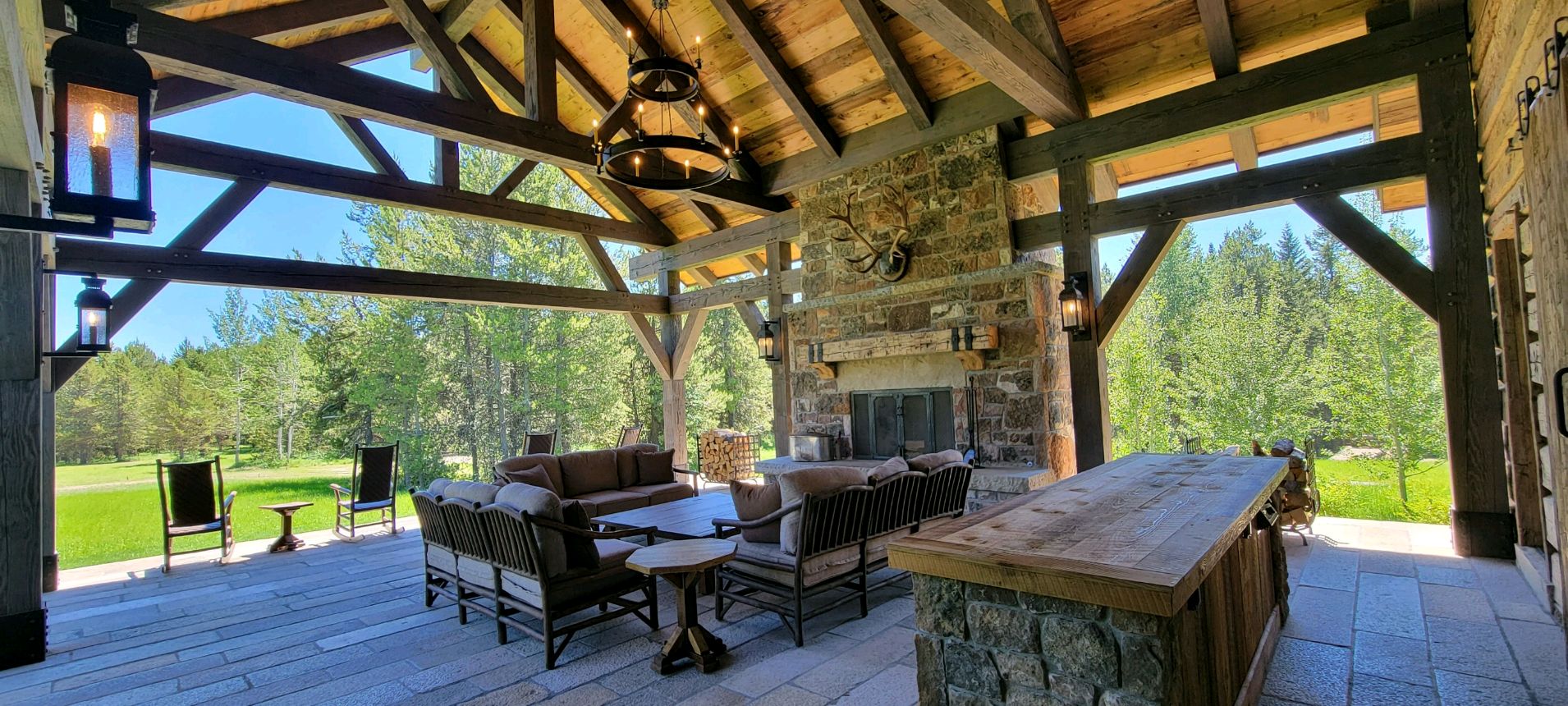 covered porch with seating area and stone fireplace