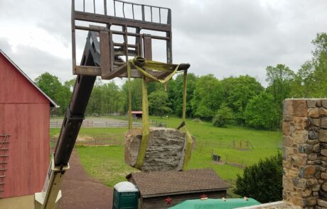 forklift raising stones to a wall